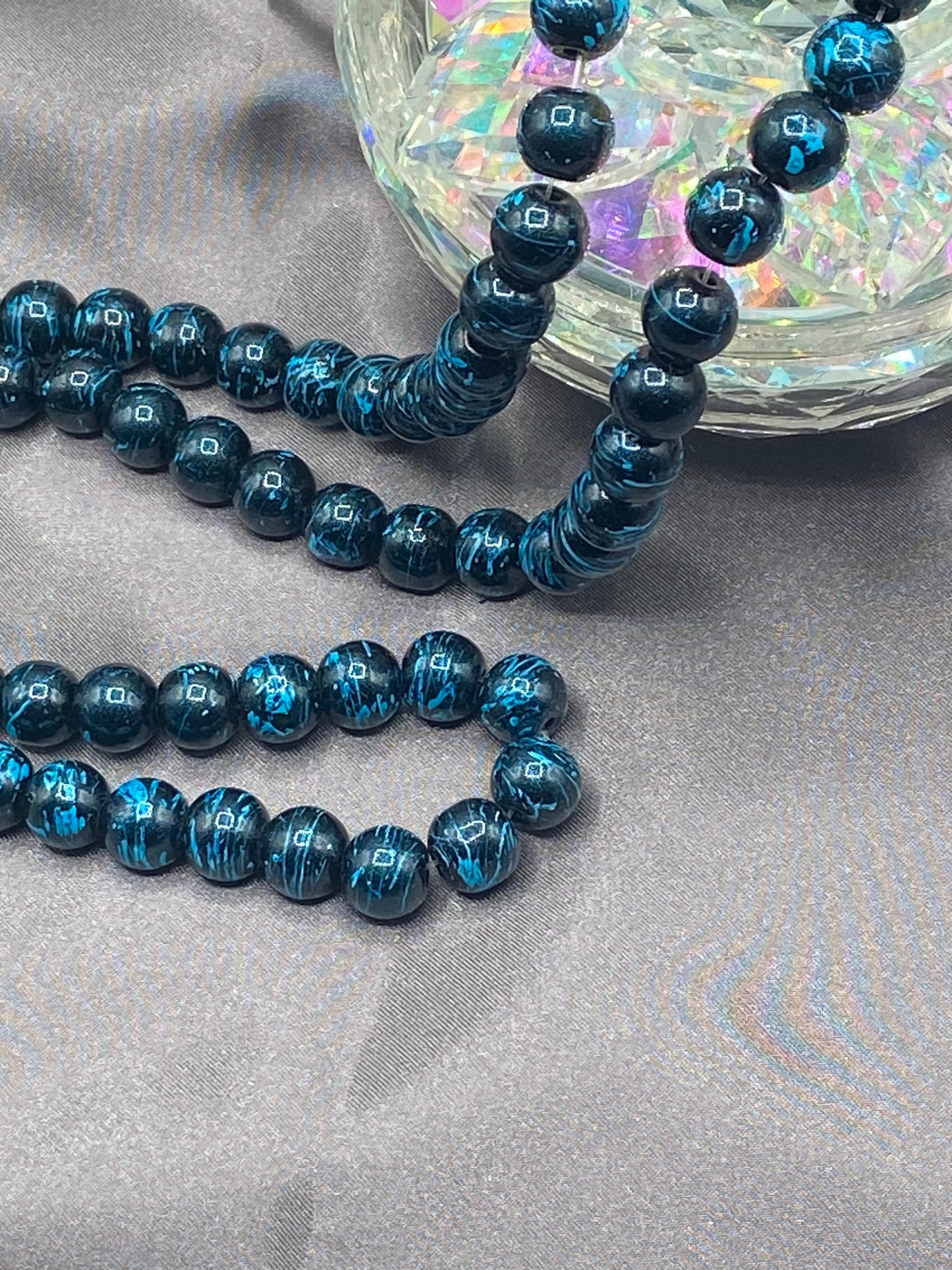 #4 turquoise and black paint splatter glass bead.